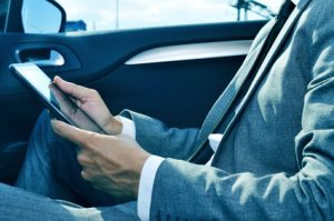 closeup of a young businessman using a tablet in a car