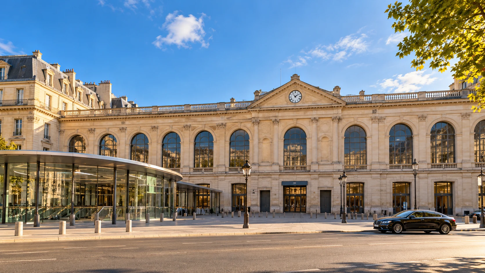 A black saloon near a pale-stone Paris station and its glass entrance under a blue sky