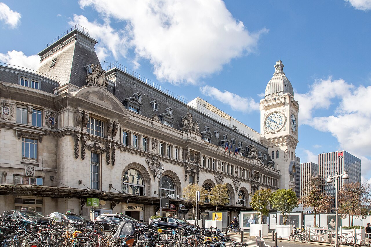Façade de la gare de Lyon à Paris et sa tour de l’horloge sous un ciel bleu.