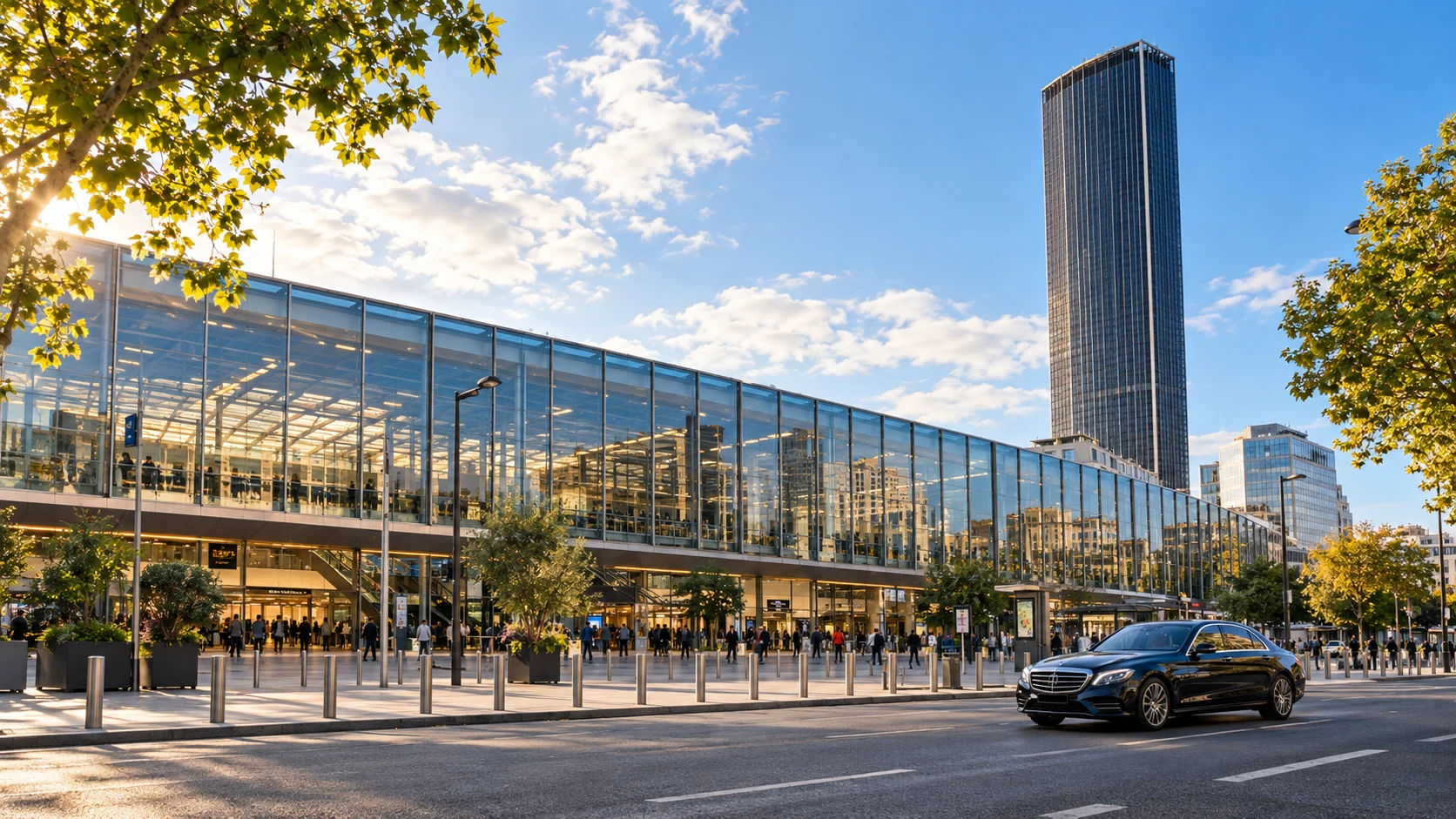 Berline noire devant une façade vitrée évoquant la gare Montparnasse et sa tour, sous le soleil parisien